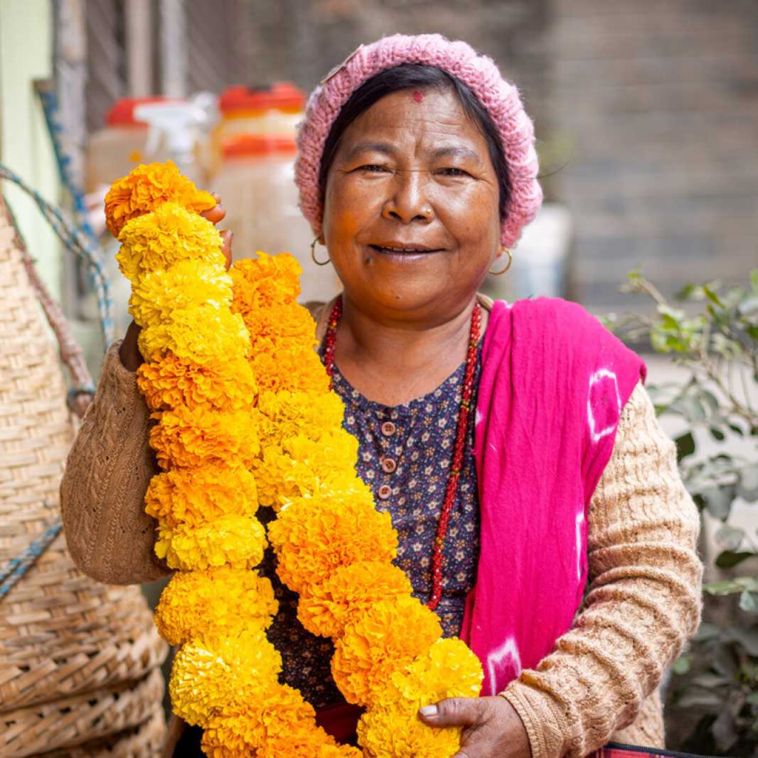 Flower farmer Shree Kumari Thapa with a marigold garland to sell.